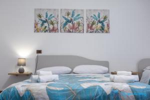 een slaapkamer met een bed en een schilderij aan de muur bij Maison du Port in Civitavecchia