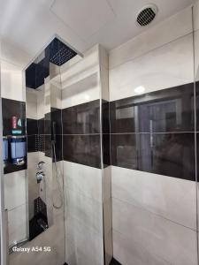 a bathroom with a shower with black and white tiles at AS luxury apartment in Athens +22 photos