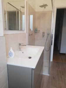 a white bathroom with a sink and a shower at Casa Parco Casale in Rapallo +26 photos