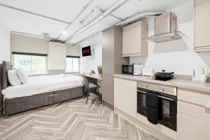 a room with a bed and a kitchen with a counter at The Lister Gate Studios in Nottingham