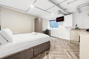 a white room with a bed and a kitchen at The Lister Gate Studios in Nottingham