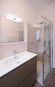 a white bathroom with a sink and a shower at Casa Parco Casale in Rapallo