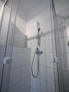 a shower in a bathroom with white tiles at Nice Apartment in Itzehoe in Itzehoe