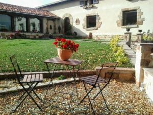 La LombaにあるPosada Rural Lindos Sueñosの花瓶付きテーブルと椅子2脚