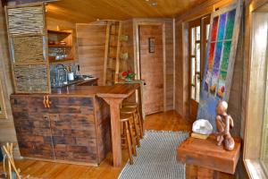 a kitchen with a wooden island in a log cabin at La Casa Del Árbol De Chiloé in Castro