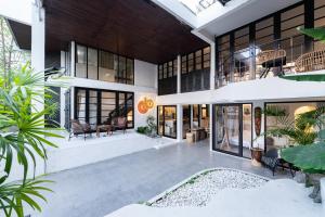 een exterieurbeeld van een huis met veel ramen bij Rwanda Naziza - Private Villa in the Old Town City - PRIME LOCATION I Daily Housekeeping in Chiang Mai