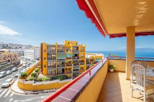 a balcony with a view of a city and the ocean at Large Terrace Jardin Apartment in Puerto de Santiago