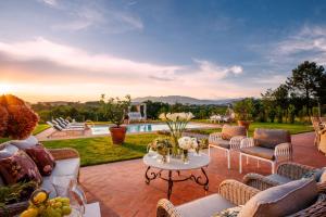 a patio with couches and a table with flowers on it at Villa Flora in Montecarlo