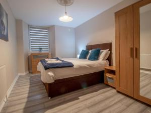 a bedroom with a bed with blue pillows at City Gem Main Door Parking Pass the Keys in Glasgow