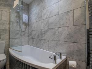 a bathroom with a bath tub and a toilet at City Gem Main Door Parking Pass the Keys in Glasgow +38 photos