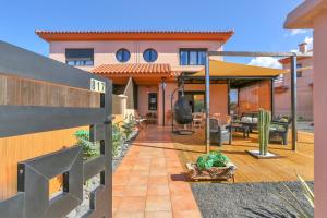 a backyard of a house with a wooden deck at La Torre del Mar, rincón del Atlántico Lajares- Origomare - Remote work in Lajares