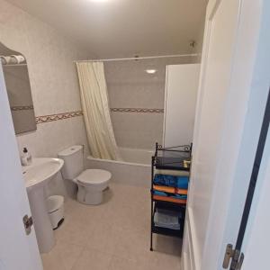 a bathroom with a white toilet and a sink at Bella in Parque Holandes