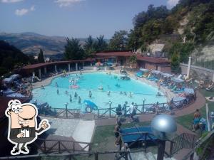 a large swimming pool with many people in it at Vannelli Rooms in Castelbottaccio