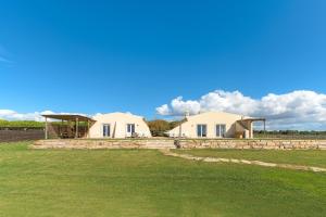 two houses in a field with a blue sky at Paraiso da Serva - Flor do Rosto 2 in Odemira
