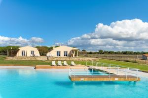 a pool of water with chairs and a house at Paraiso da Serva - Flor do Rosto 2 in Odemira