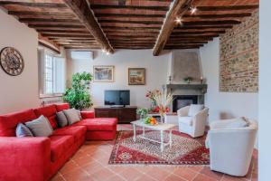 a living room with a red couch and a fireplace at Villa Papari in Montecarlo