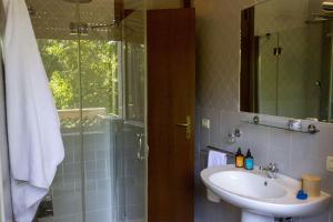 Un baño con lavabo y ducha con espejo. en Appartamento Percoto, en Udine