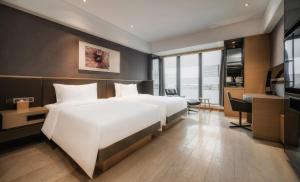 Postelja oz. postelje v sobi nastanitve Grand Metropark Hotel Shanghai Pudong