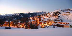 una ciudad en la nieve con montañas cubiertas de nieve en Adonis Le Chastellan, en Valberg