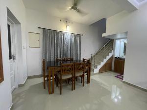 a dining room with a table and chairs and a staircase at The Dream Home Kochi in Cochin +5 photos