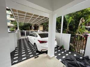 a white car parked on a driveway in a house at The Dream Home Kochi in Cochin