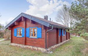 HayingenにあるFerienhaus Donau 56の野原に建つ青い窓のある小さな木造の家