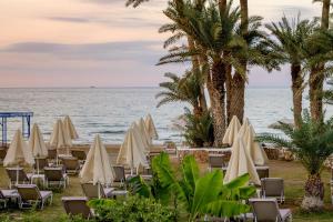 a beach with chairs and umbrellas and the ocean at Zeus Hotels Palm Beach in Stalís