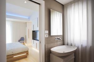 Un baño con inodoro, lavabo y cama. en Canticle Lucca Luxury Apartment, en Lucca 28 fotos más