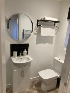 a bathroom with a white toilet and a mirror at Guest house paradiso in Great Cornard