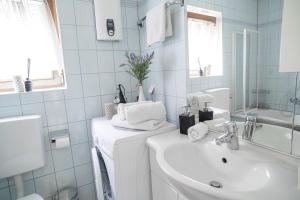 biała łazienka z umywalką i lustrem w obiekcie FarawayHomes Studio St Wolfgang #4 w mieście Ried +16 zdjęć