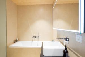 a bathroom with a tub and a white sink at La Ruinette-large1 Bed, Close To The Lift in Le Châble +4 photos