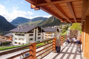 a person sitting in a chair on the balcony of a house at La Ruinette-large1 Bed, Close To The Lift in Le Châble