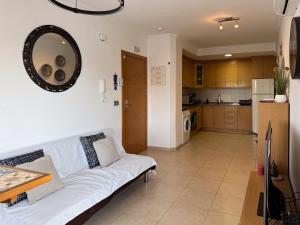 a living room with a white couch and a kitchen at Aire de Levante in Alicante +12 photos