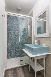une salle de bain avec un lavabo bleu et une douche dans l'établissement B&B La Fenice, à Bologne 27 autres photos