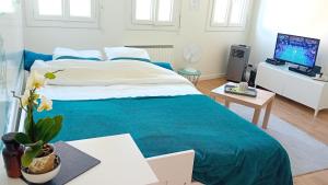 une chambre avec un grand lit avec une couverture bleue dans l'établissement STUDIO NEUF PARKING SECURISE Direct CDG et PARIS CENTRE Parc expo Villepinte & Arena Grand Paris, à Tremblay-en-France 51 autres photos