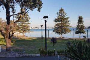 una luz de la calle en un parque junto a un cuerpo de agua en The 2 Bedroom Hurstville Haven, en Sídney