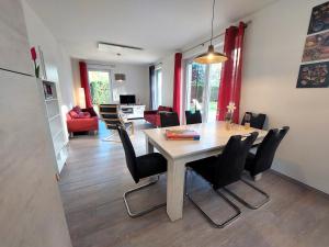 a dining room and living room with a table and chairs at Ferienhaus "Unser neues Haus" in Trassenheide