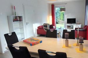 a room with a table with chairs and a living room at Ferienhaus "Unser neues Haus" in Trassenheide