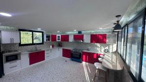 a kitchen with red and white cabinets and appliances at Red_Hut_Resort in Hatta
