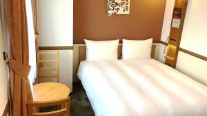 a small bedroom with a bed and a chair at Toyoko Inn Morioka Ekimae in Morioka