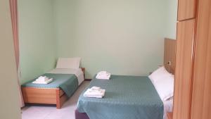 two beds in a small room with towels on them at Casa ATENA in Villa dʼAlmè +9 photos