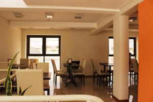 a dining room with tables and chairs and windows at Hotel Chardonnay in Tupungato
