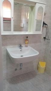 a bathroom with a white sink and two mirrors at Casa ATENA in Villa dʼAlmè