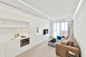 a white living room with a couch and a kitchen at City Centre Studio Apartments Nicosia in Nicosia
