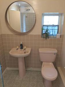 a bathroom with a toilet and a sink and a mirror at Willow Cottage in Rye
