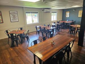 an empty restaurant with wooden tables and chairs at Hotel Thangool in Thangool