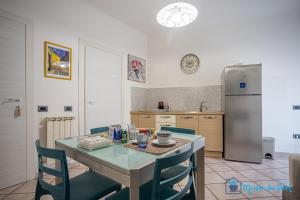a kitchen with a table with chairs and a refrigerator at Maison du Port in Civitavecchia