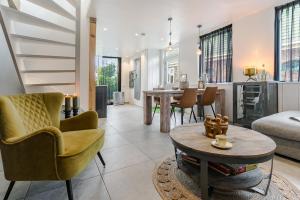 a living room with a couch and a table at Luxury apartment in farmhouse near Amsterdam in Ilpendam