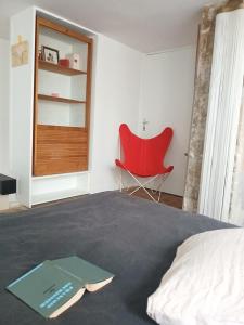 a bedroom with a red chair and a bed at Stipologic 6P 2BR in Paris