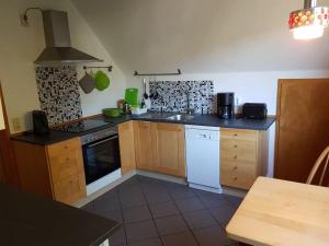 a kitchen with wooden cabinets and white appliances at Art-Apartment mit Balkon in Bad Karlshafen